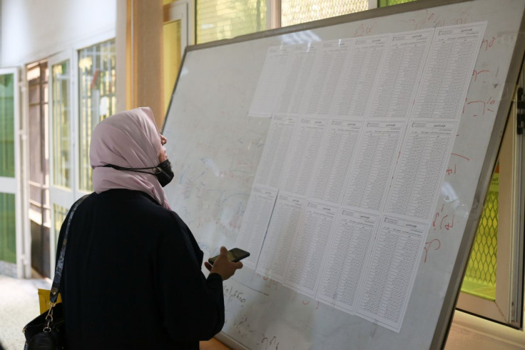 A woman checks names to receive her electoral card inside a polling station in Tripoli, Libya, November 8, 2021. 