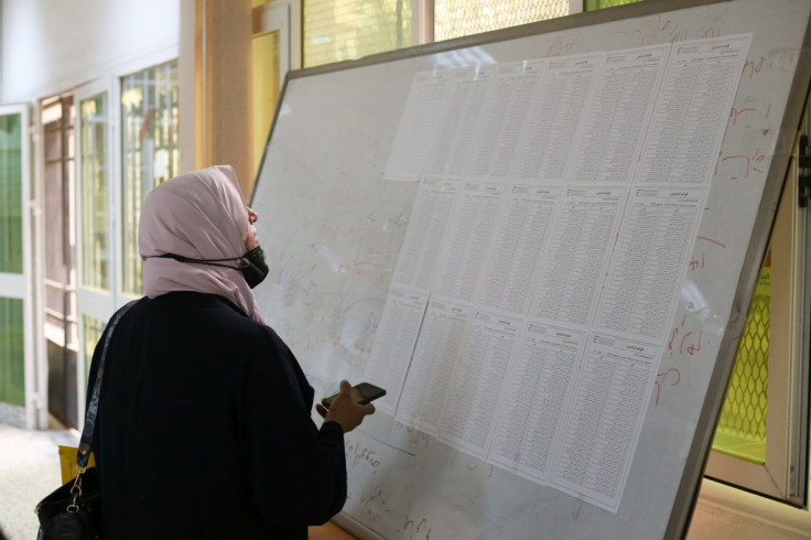 A woman checks names to receive her electoral card inside a polling station in Tripoli, Libya, November 8, 2021.