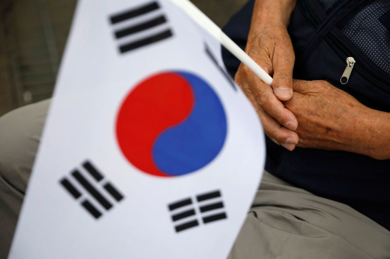 A South Korean war veteran holds the national flag during a ceremony commemorating the 70th anniversary of the Korean War, near the demilitarized zone separating the two Koreas, in Cheorwon, South Korea, June 25, 2020. 