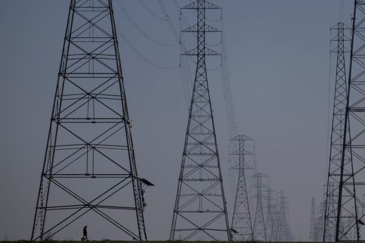 A local resident walks by the power grid towers at Bair Island State Marine Park in Redwood City, California, United States, January 26, 2022. 