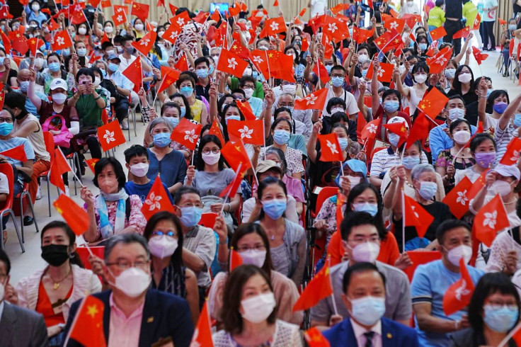 People wave Chinese and Hong Kong flags during a celebration event for the 25th anniversary of Hong Kong's handover to China from Britain, in Hong Kong, China June 26, 2022.  