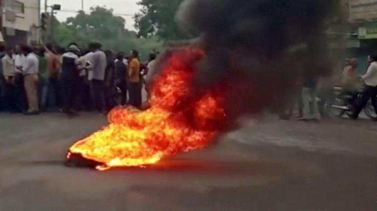 Smoke rises from a burning material while people gather on road as tensions rise after the killing of a Hindu man, in Udaipur, Rajasthan, India June 28, 2022 in this still image obtained from a handout video. ANI/Handout via REUTERS 