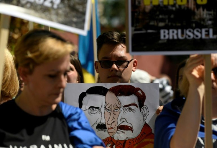 Protestors hold placards as a demonstration takes place on the situation in Ukraine, during the NATO summit in Madrid