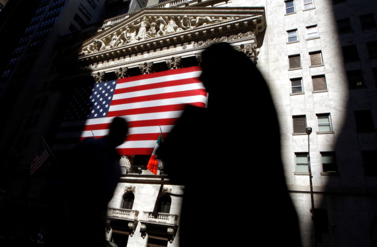 The sun lights the exterior of the New York Stock Exchange, as people walk past on the shadowed street, July 16, 2008.  