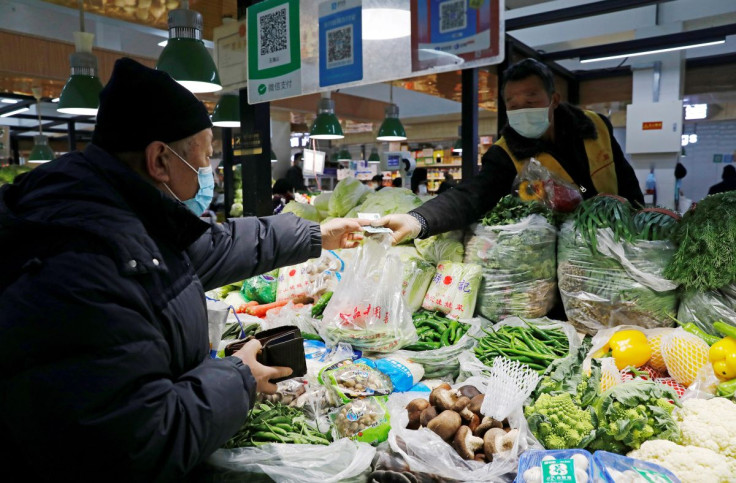 People wearing face masks shop at a market, following new cases of the coronavirus disease (COVID-19) in the country, in Beijing, China January 11, 2021.