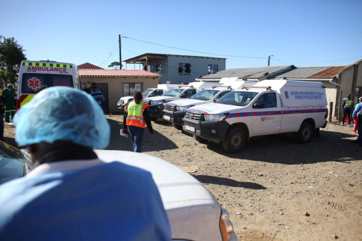 Mortuary vans are seen as forensic personnel load bodies of victims after the deaths of patrons found inside the Enyobeni Tavern, in Scenery Park, outside East London in the Eastern Cape province, South Africa, June 26, 2022. 