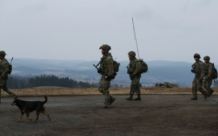 U.S. Army soldiers from the 82nd Airborne Division walk towards an airbase, near Arlamow