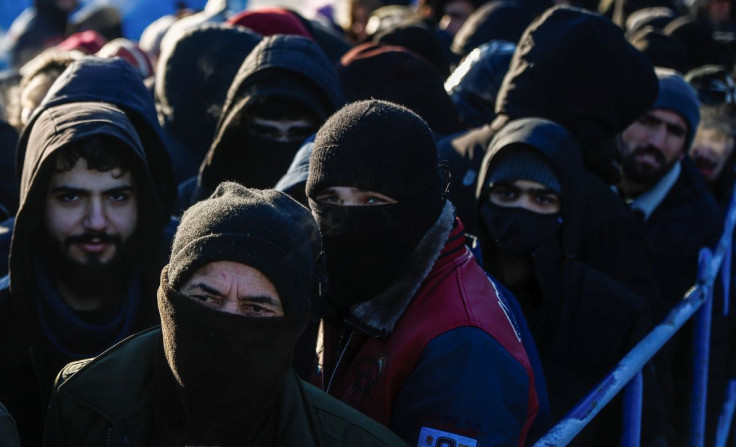 Migrants queue to receive meals outside the transport and logistics centre Bruzgi on the Belarusian-Polish border, in the Grodno region, Belarus December 22, 2021. 