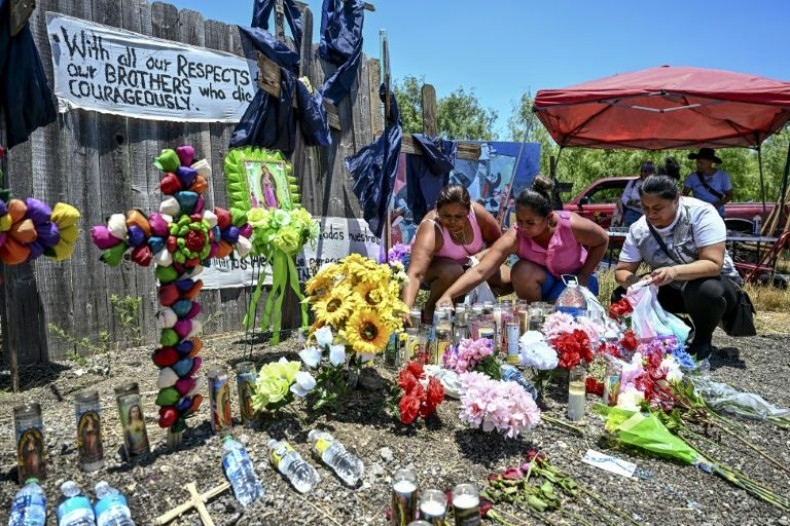 People place flowers, candles and water bottles at a makeshift memorial to the 53 migrants who died after being abandoned by smugglers in a tractor-trailer near San Antonio, Texas.