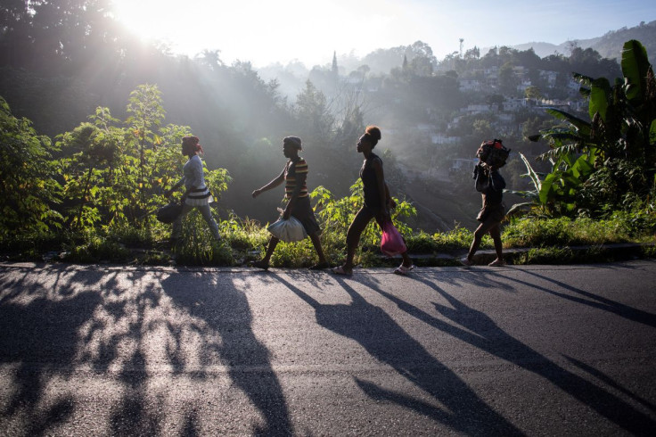 Women walk along the roadside as they head towards a market in Fermate, Haiti, October 26, 2021.  