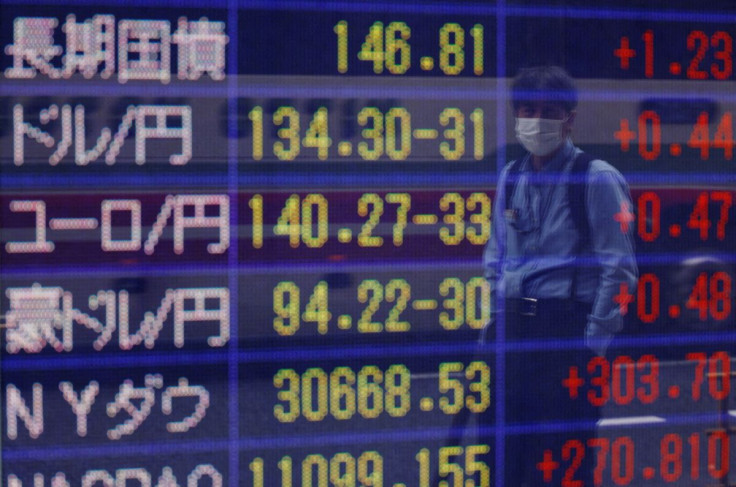 A man wearing a protective mask amid the coronavirus disease (COVID-19) outbreak, looks at a board displaying the Japanese yen exchange rate against the U.S. dollar outside a brokerage in Tokyo, Japan June 16, 2022. 