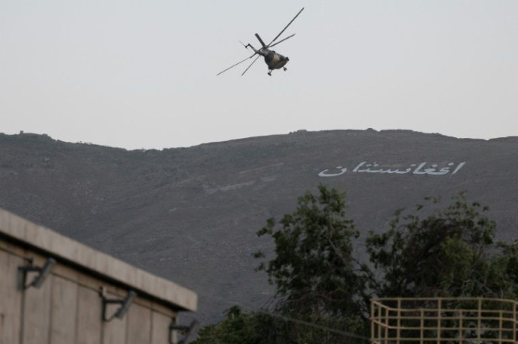 A military helicopter flies above the green zone in Kabul as thousands of religious scholars gathered for a meeting likely to endorse the Taliban's rule