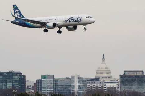 An Alaska Airlines aircraft flies past the U.S. Capitol before landing at Reagan National Airport in Arlington, Virginia, U.S., January 24, 2022.   