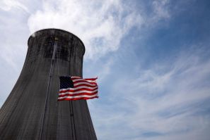 The US flag flies at half mast in front of a coal-fired power plant's cooling tower at Duke Energy's Crystal River Energy Complex in Crystal River, Florida, U.S., March 26, 2021. 