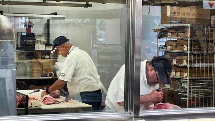 Owner, William Begale, and one of his employees cut meat in the butcher's cutting room at Paulina Meat Market in Chicago, Illinois, U.S., June 28, 2022. 