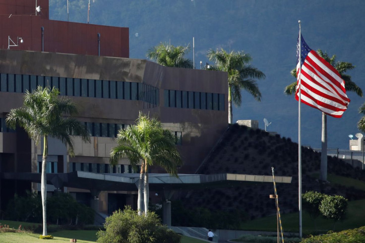 A man walks next to a U.S. flag at the U.S. Embassy in Caracas, Venezuela January 24, 2019.   