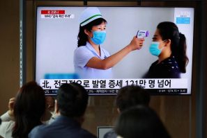 People watch a TV broadcasting a news report on the coronavirus disease (COVID-19) outbreak in North Korea, at a railway station in Seoul, South Korea, May 17, 2022.    