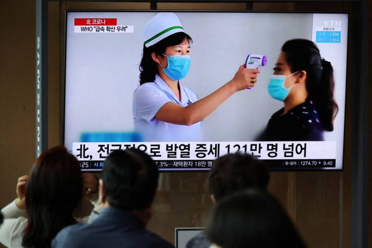 People watch a TV broadcasting a news report on the coronavirus disease (COVID-19) outbreak in North Korea, at a railway station in Seoul, South Korea, May 17, 2022.    