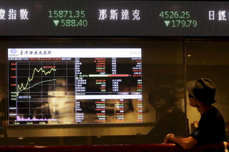 A man looks at a screen showing stock market prices inside a brokerage in Taipei, Taiwan, August 25, 2015. 