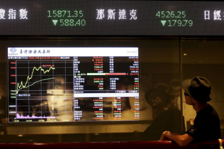 A man looks at a screen showing stock market prices inside a brokerage in Taipei, Taiwan, August 25, 2015.