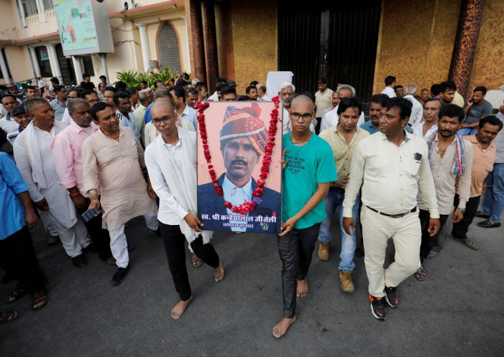 Two sons of Kanhaiyalal Teli, a Hindu tailor, who was killed by two suspected Muslims after they videoed themselves slaying him, carry a portrait of their father after a prayer meeting in Udaipur in the northwestern state of Rajasthan, India, June 30, 202
