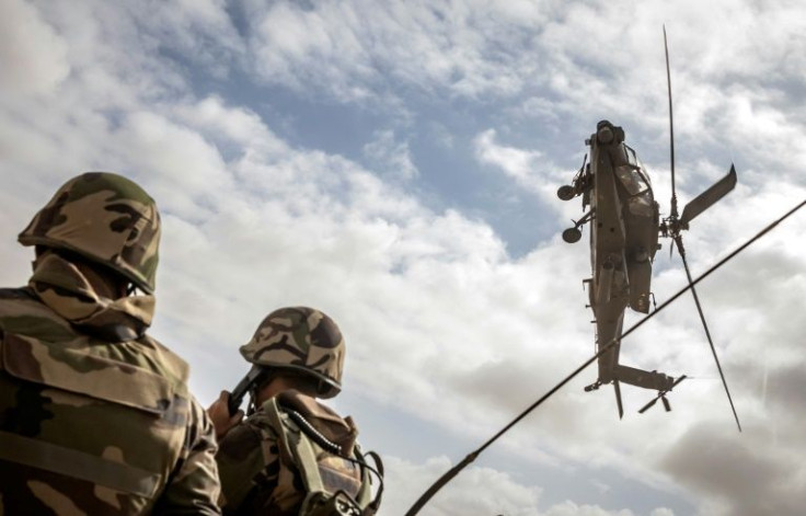 A US army AH-64 Apache attack helicopter flies over members of the Moroccan Royal Armed Forces during the second annual "African Lion" military exercise on June 30