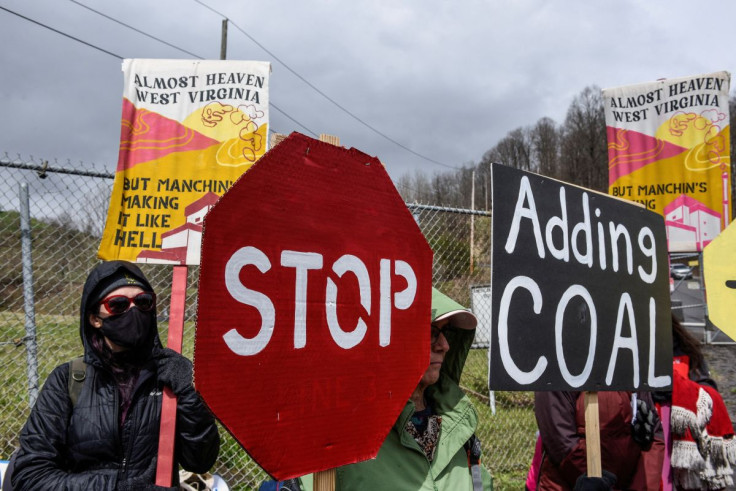 People hold signs as they protest against U.S. Senator Joe Manchin (D-WV) as they blockade the Grant Town Coal Waste Power Plant in Grant Town, West Virginia, U.S., April 9, 2022.  