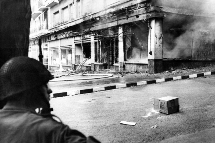 In this file picture taken on May 15, 1962, a French soldier looks at a store destroyed by a Molotov cocktail in Algiers
