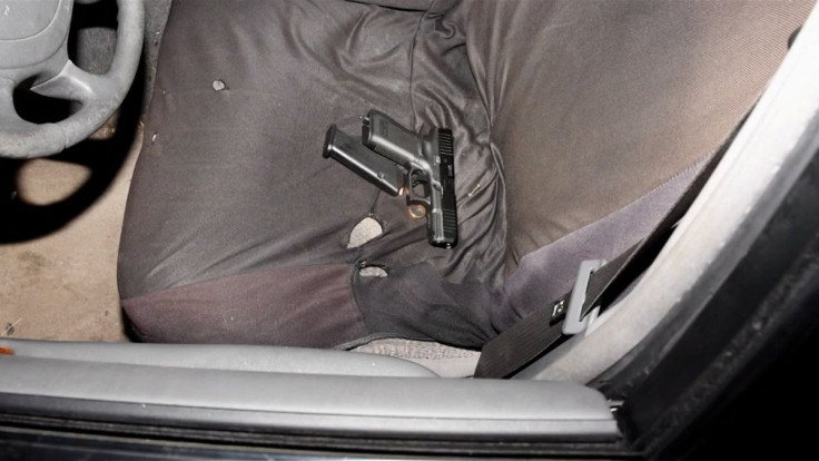 A handgun, loaded magazine and a gold ring are seen on the front seat of the vehicle of Jayland Walker, who was shot to death by up to eight officers, in Akron, Ohio, U.S. June 25, 2022 in a still image from a police video presentation. City of Akron/Hand