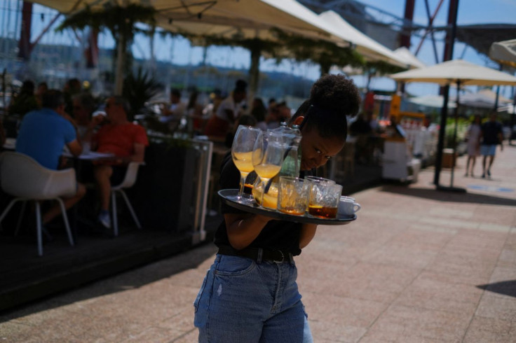 A waitress removes drinks from a table in a restaurant in Lisbon, Portugal, June 6, 2022. Picture taken June 6, 2022. 