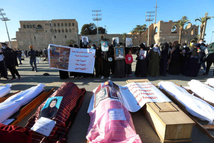 Mourners show portraits near bodies which were exhumed from a mass grave in Tarhouna, before getting reburied in Tripoli, Libya January 22, 2021.