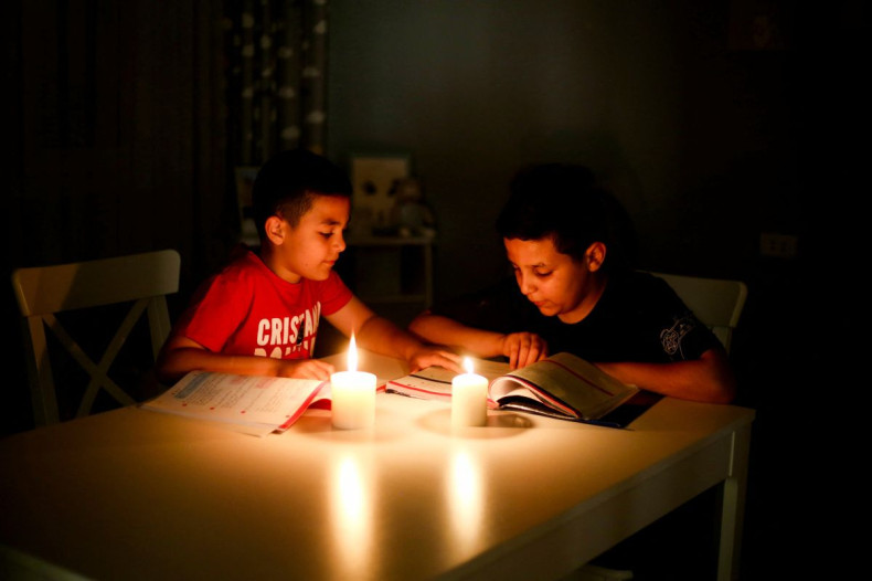 Children study by candlelight during a power outage, at home in  Tripoli, Libya June 30, 2022. Reuters/Hazem Ahmed