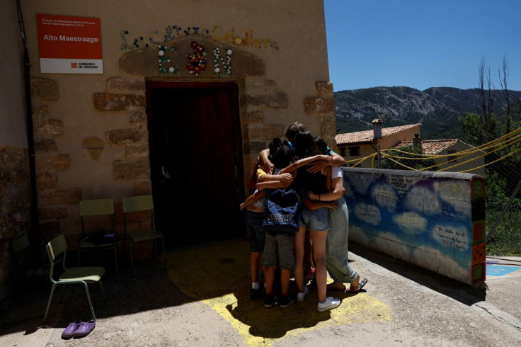 Alberto Toro, his current students and two former students of his who came to say good-bye, blend into a hug on the last day of school in the small Spanish village of Pitarque, Teruel, one of the least populated regions of the European Union, June 21, 20