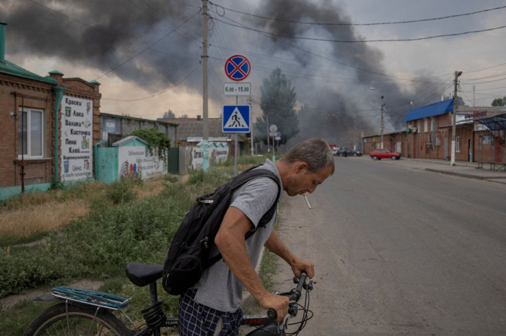 A man pushes a bicycle across a street in front of the market after shelling, as Russiaâs attack on Ukraine continues, in Sloviansk, Donetsk region, Ukraine, July 5, 2022.