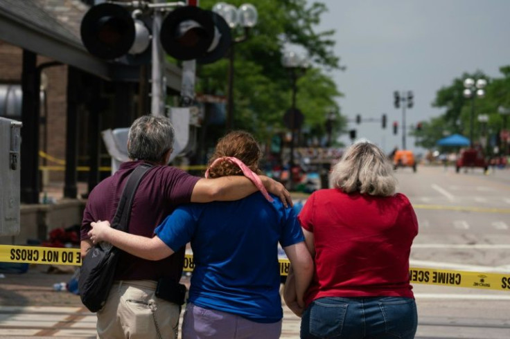 A family embraces while observing the scene of a mass shooting at a July 4th Parade in downtown Highland Park, Illinois on July 5, 2022