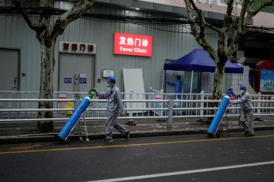 Workers deliver oxygen cylinders outside the fever clinic of a hospital during lockdown amid the coronavirus disease (COVID-19) pandemic, in Shanghai, China April 14, 2022. 