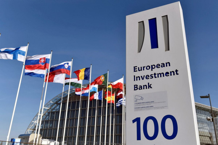 Flags are seen behind the logo of the European Investment Bank pictured in the city of Luxembourg, Luxembourg, March 25, 2017. Reuters/Eric Vidal