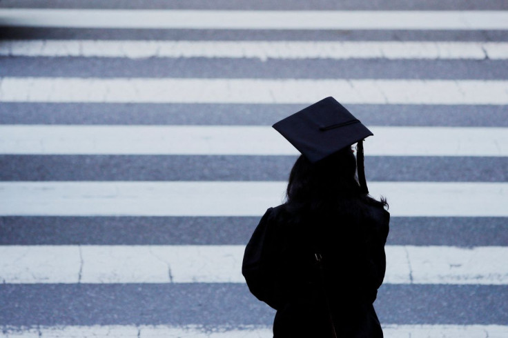 A graduating student waits to cross the street before Commencement Exercises at the Massachusetts Institute of Technology (MIT) in Cambridge, Massachusetts, U.S., June 7, 2019.   
