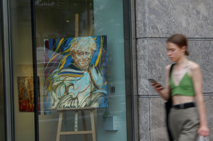 A woman walks past a portrait of British Prime Minister Boris Johnson displayed at a gallery, as Russiaâs attack on Ukraine continues, in Kyiv, Ukraine July 6, 2022. 