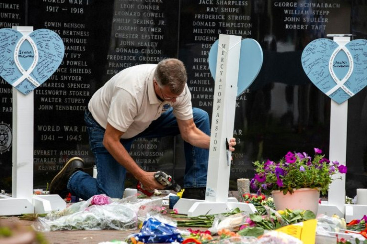 A member of the Lutheran Church Charities assembles a memorial for the victims of a mass shooting at July 4 parade in Highland Park, Illinois