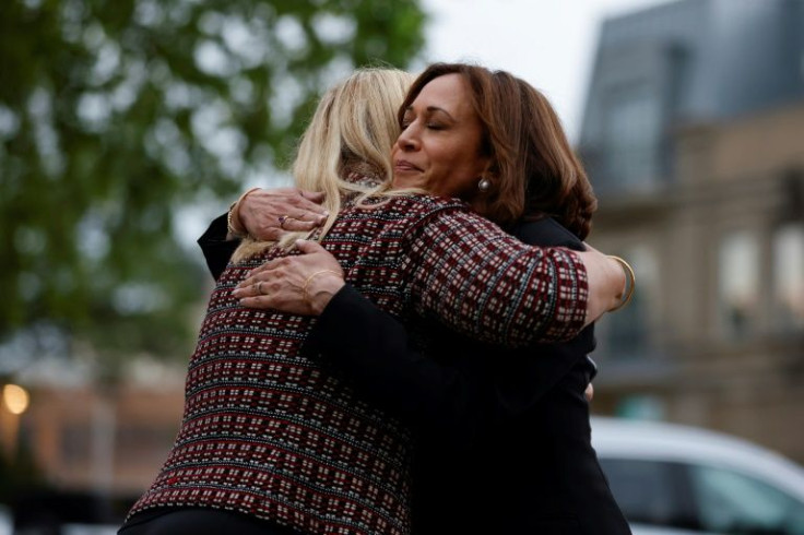 US Vice President Kamala Harris (R) hugs Highland Park Mayor Nancy Rotering (L) during a visit to the site of a shooting that left seven people dead in Highland Park, Illinois