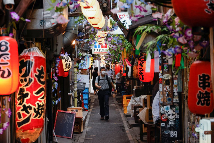 People wearing protective masks walk at a Japanese Izakaya pub alley, amid the coronavirus disease (COVID-19) outbreak, in Tokyo, Japan July 6, 2022.  