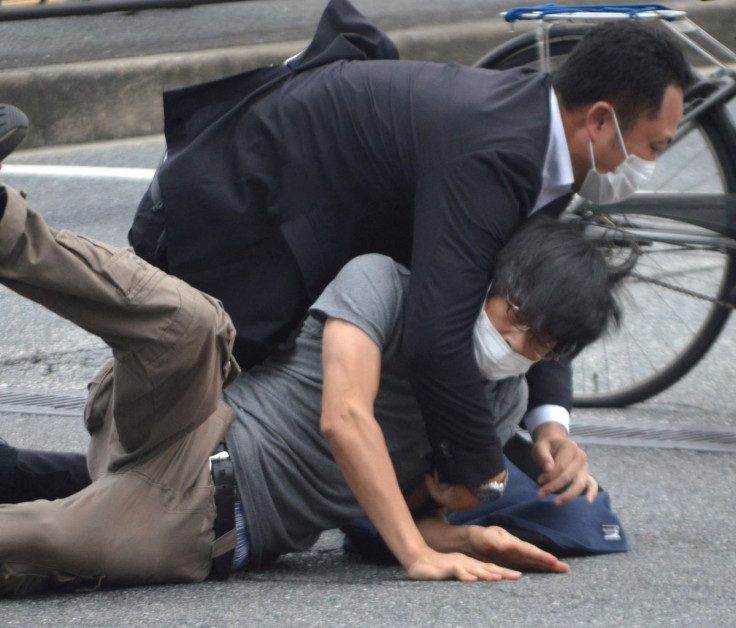 A man, believed to be a suspect shooting Japanese Prime Minister Shinzo Abe is held by police officers at Yamato Saidaiji Station in Nara, Nara Prefecture on July 8, 2022 in this photo taken by the Yomiuri Shimbun. The Yomiuri Shimbun/KYODO via REUTERS 