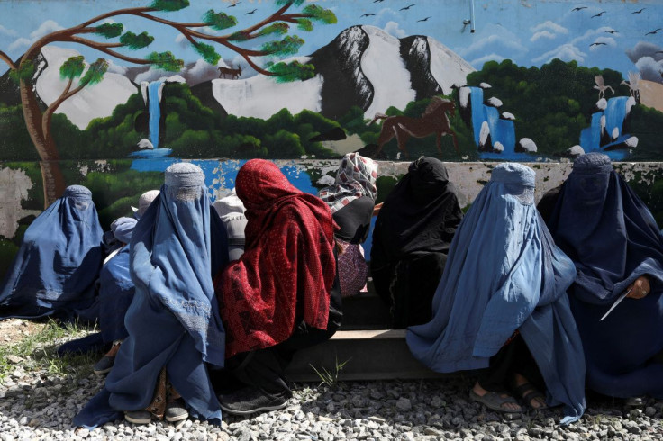 Afghan women wait to receive a food package being distributed by a Saudi Arabia humanitarian aid group at a distribution center in Kabul, Afghanistan, April 25, 2022.