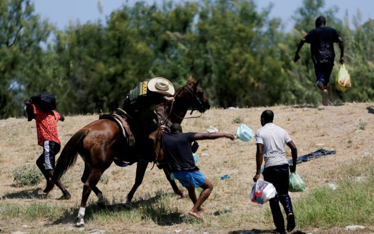 A U.S. border patrol officer grabs the shirt of a migrant trying to return to the United States along the Rio Grande river, after having crossed from the United States into Mexico to buy food, as seen from Ciudad Acuna, in Ciudad Acuna, Mexico September 1