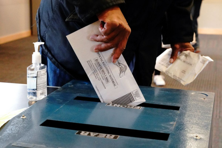 A voter casts his ballot next to a bottle of hand sanitizer at the Milwaukee Public Libraryâs Washington Park location in Milwaukee, on the first day of in-person voting in Wisconsin, U.S., October 20, 2020. Wisconsinâs early voting period, known as a