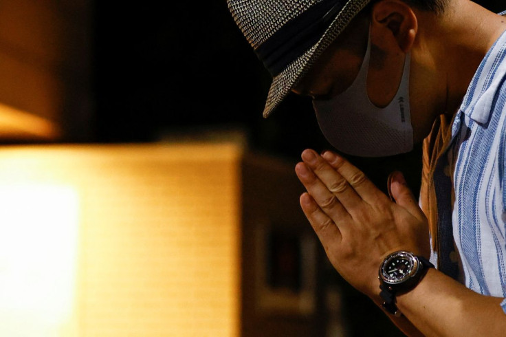 A man prays as he mourns former Japanese Prime Minister Shinzo Abe, who was shot while campaigning for a parliamentary election, outside his residence in Tokyo, Japan July 9, 2022.