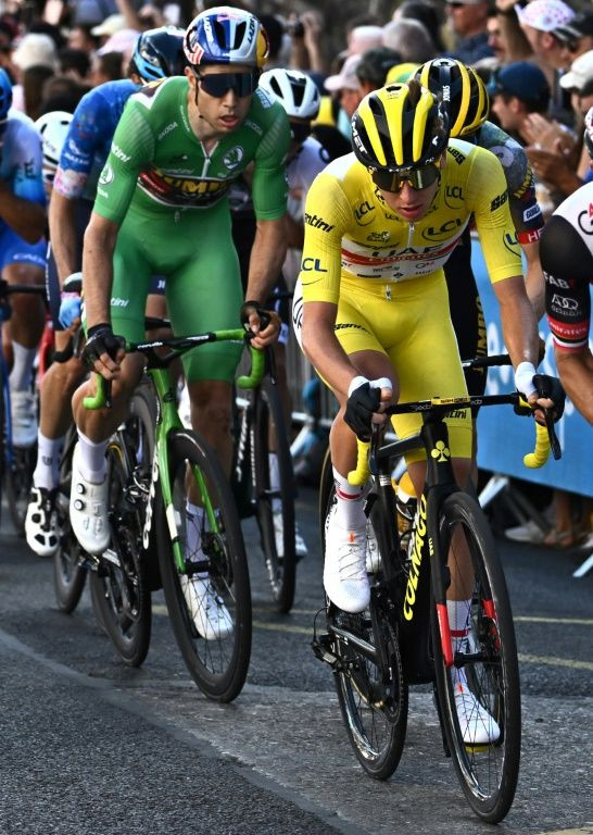Slovenian Tadej Pogacar (R), wearing the overall leader's yellow jersey, followed by Belgian Wout Van Aert (L) in the sprinter's green jersey