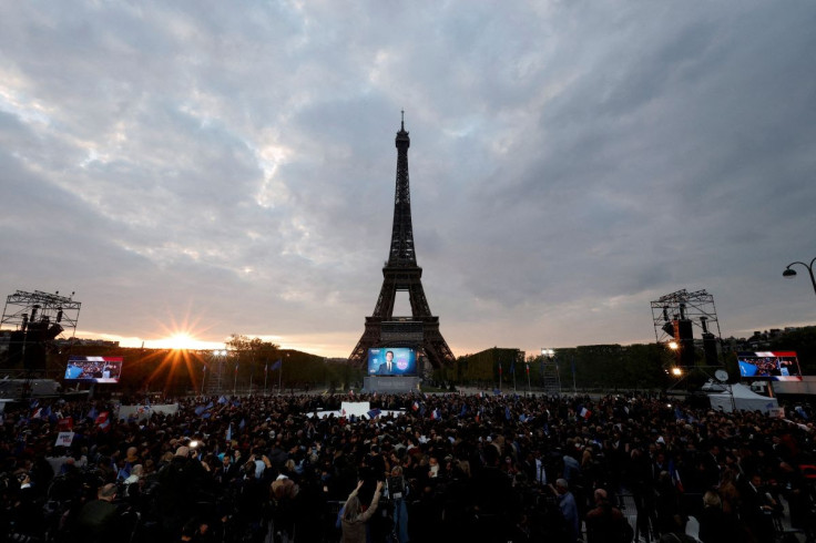 Macron, candidate for his re-election, react after the results in the second round vote of the 2022 French presidential election, near Eiffel Tower, at the Champs de Mars in Paris, France April 24, 2022.