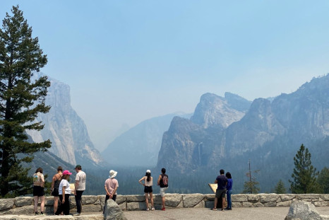 Visitors check out the view from the east end of the Wawona Tunnel into Yosemite Valley, showing three major landmarks, from the left, El Capitan, Half Dome and Bridalveil Fall, obscured by thick smoke in the area from the wildfire burning to the south in